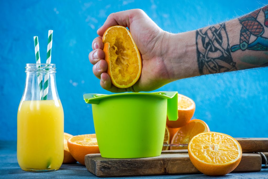 Grow Your Revenue with Existing Customers​ shown by a hand squeezing an orange, signifying revenue