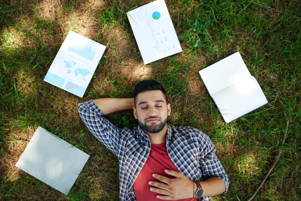 Scale your WordPress Business - Male taking a break from work. Lying down with paperwork around him