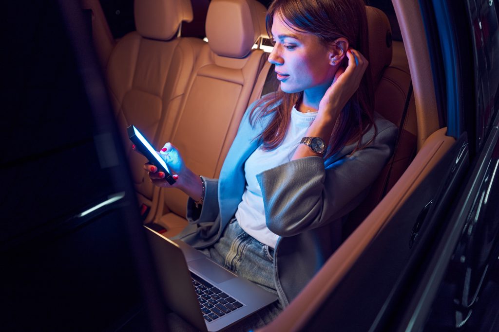 Woman Using smartphone in car showing 'seamless user experience'